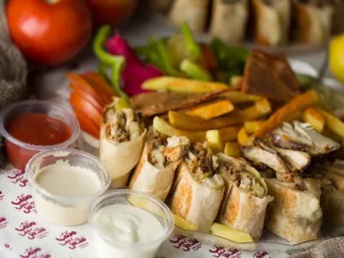 Shamiyat Chicken Shawerma Meal - Platter of chicken shawarma saj bites with fries, garlic sauce pickles and soft drink.