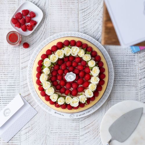 Vanilla Cheesecake With Berries And White Natural Roses - With strawberry sauce.