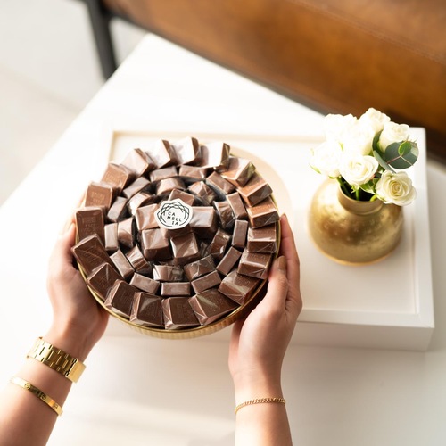 Golden gift chocolate - A luxurious gift set containing a 650g chocolate platter with a beautiful small vase of roses, presented in a cardboard tray.