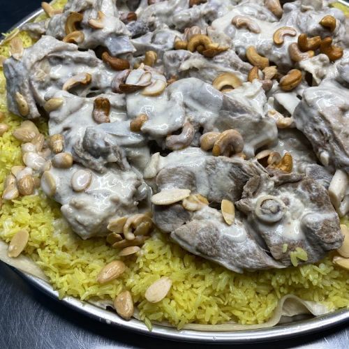 منسف أردني لحم عربي نعيمي مطبوخ و محضر بالجميد الكركي مع الأرز الخاص و عليه المكسرات و يقدم مع الجمي