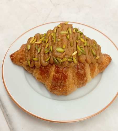 Pistachio Croissant - croissant filled with pistachio paste and topped with crushed pistachios.