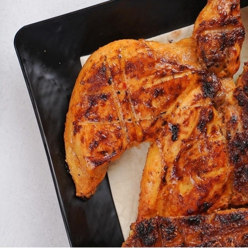 Boneless Chicken - A whole chicken grilled on the charcoal with a potato and Iranian bread, a salad