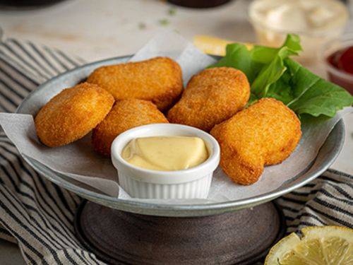 Chicken Nuggets - 5 Pieces breaded chicken nuggets served with honey mustard sauce.