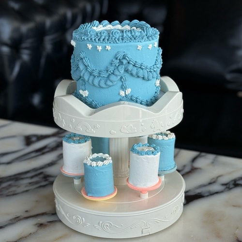 Vola Cake - Blue - Rotating music cake stand with a small cake on top filled with layers of brownie, red velvet, and rich cheese cream, 6 mini cakes below, and a complimentary candle.