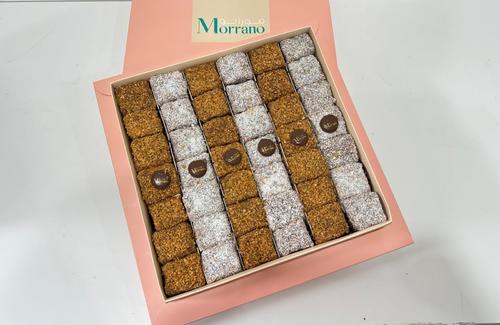Pinacolada Deluxe - Thin and fluffy slices of pineapple cake Drenched in Swiss cocoa sauce with soft and rich grains of caramelized coconut flakes and original Box of 42 pieces