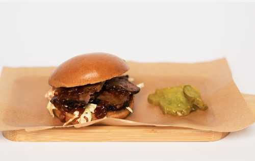 The Brisket Burger - 1/2 pound sliced smoked beef brisket, lettuce, tomato, caramelized onion, pickles, mayonnaise & bbq sauce.