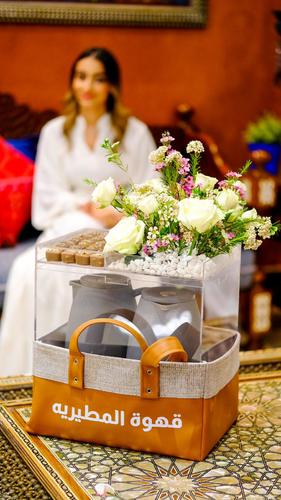 LEATHER BASKET WITH FLOWERS AND SWEETS - A leather basket with raw material in an acrylic box with the phrase change, coffee sweets, natural roses, in addition to rocks, and Dalal for coffee and tea. Please note flowers are seasonal and we change the flower depending on the availability of the stocks.