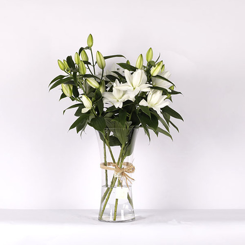 Riana - A bouquet of double lilies arranged in a glass vase.