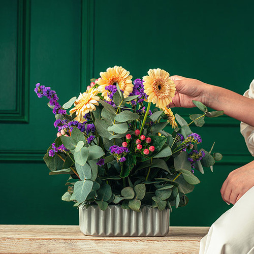 Garden - A bouquet of gerbera, statice, hypericum and eucalyptus arranged in a square ceramic vase. 
    H 35 x W 20