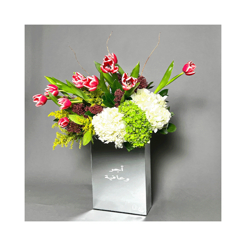 Simply You - A mirror vase with tulips, hydrangea and greens.
 Height: 72cm  Width: 50cm  Sell by: Quantity