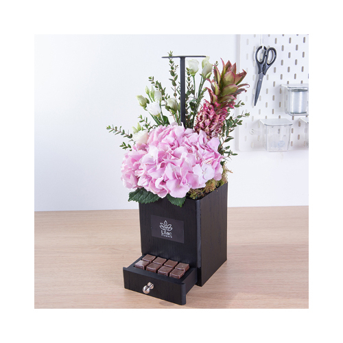 Half Tropical - This black wooden handle contains pink hydrengia, esthoma, eucalyptus and pineapple with Belgian chocolates.
 Height: 25cm  Width: 45cm  Sell by: Quantity