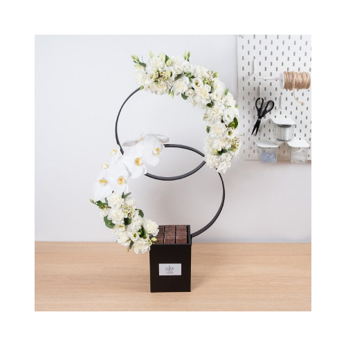 Pretty In White - This double rings stand contains cat flower, carnation, eustoma all in white with Belgian chocolates. 
Height: 85cm  Width: 50cm  Sell by: Quantity