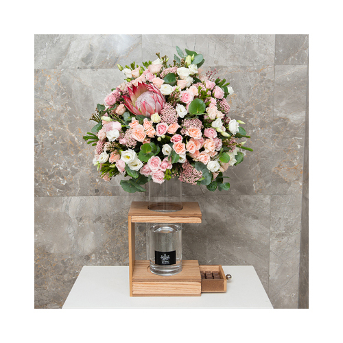 Pink Blossom - This wooden basket, brown color contains king protea, eustoma, rise flower and mix of baby roses with Belgian chocolates. Height: 90cm  Width: 57cm  Sell by: Quantity