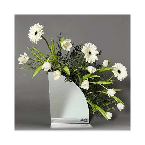 Just White - This mirror vase contains white gerbera and tulip flowers with green leaves. You can write any name or phrase on the vase.
 Height: 60cm  Width: 60cm  Sell by: Quantity