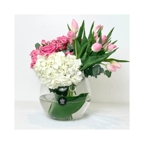 Tulips Fantasy - Around glass vase with mixed flowers of pink roses, baby roses, tulips and white hydrangea with green leaves.
 Height: 35cm  Width: 30cm  Sell by: Quantity