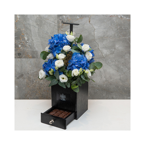 Lapis - This black wooden basket contains blue hydrangea, white roses with Belgian chocolates.
 Height: 45cm  Width: 25cm  Sell by: Quantity