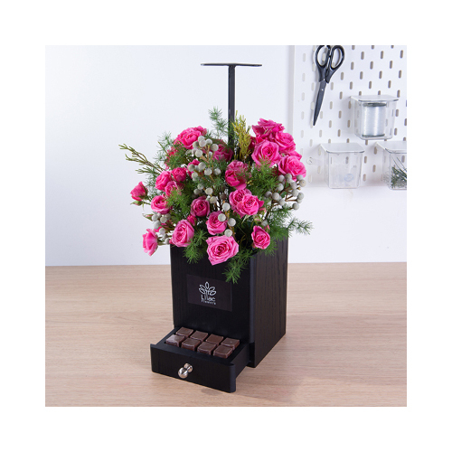 Coquette - This black wooden handle contains baby rose, safari and asparagus with Belgian chocolates. 
Height: 25cm  Width: 45cm  Sell by: Quantity