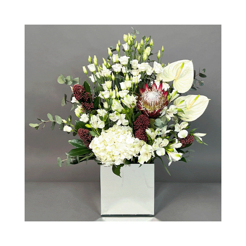 Red And White - A mirror vase with white eustoma, white anthurium، white hydrangea and red sugarbushes. 
Height: 65cm  Width: 50cm  Sell by: Quantity