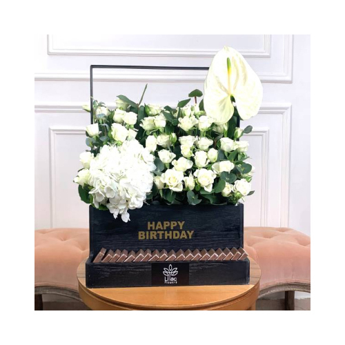 White Night 6 - A black wooden box full of white baby roses, hydrangea and anthurium with Belgian chocolates and Happy birthday label.
 Height: 43cm  Width: 45cm  Sell by: Quantity