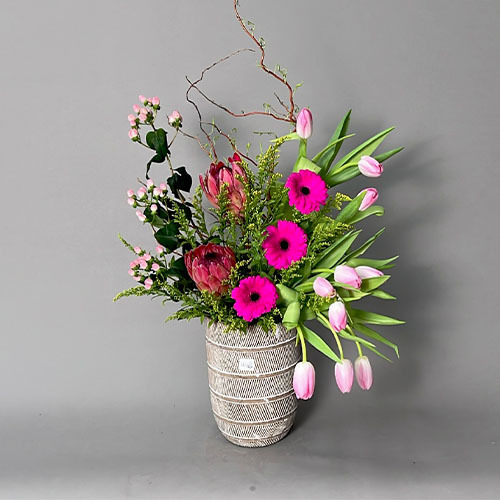 Dana - Ceramic grey vase with pink tulip, fuchsia Gerbera, pink hypericum and protae  Height 70 Width 40