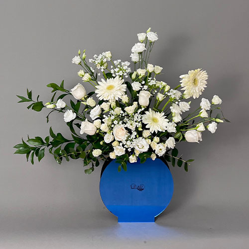 Blue and White - Blue vase with white baby rose, white rose, white eustoma, white Gerbera and greens  
 Height 80  Width 75