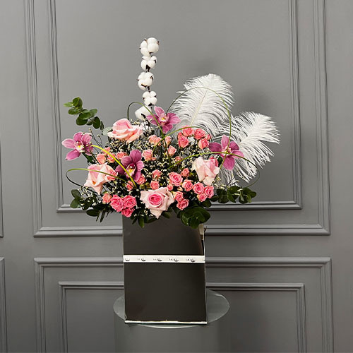 Pink and Feathers - Mirror vase with pink rose, pink baby rose, cymbidium and white feathers  Height 90  Width 68