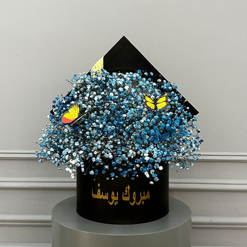 Just blue - personalized black graduation cap contain blue gypsophila and butterflies Optienal: writing on the item maximum 18 characters 
 Height 45  Width 40