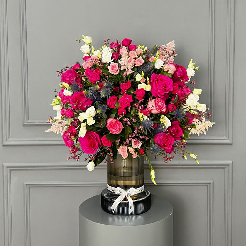 All Pink - Glass vase with fuchsia roses, fuchsia baby roses, white estoma, blue Orion and pink astible. 
 Height 74 Width 57