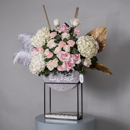 White & Gold - Stand contain white Hydrangea, white rose, pink rose, pink carnation, golden flower accessory, white feather and Belgien chocolate. Height 97  Width 75