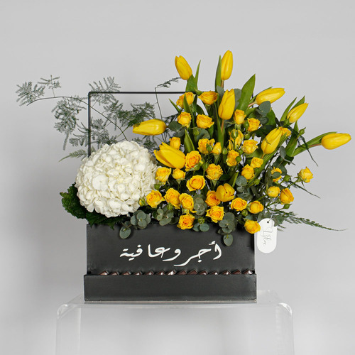 Gillian - Wooden black basket contain yellow tulips, yellow baby rose, white hydrangea and begin chocolate. Height 45 Width 57