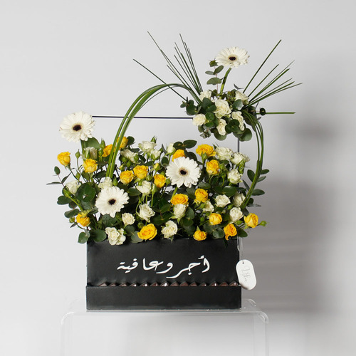 Eleanor - Wooden black basket contain white Garbera, yellow baby rose, white baby rose with Belgian chocolate. Height 50 Width 57