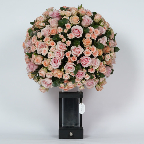 Jori 2 - Glass on black wood stand contains baby rose and a 100 roses peach and pink. Height 95 Width 75