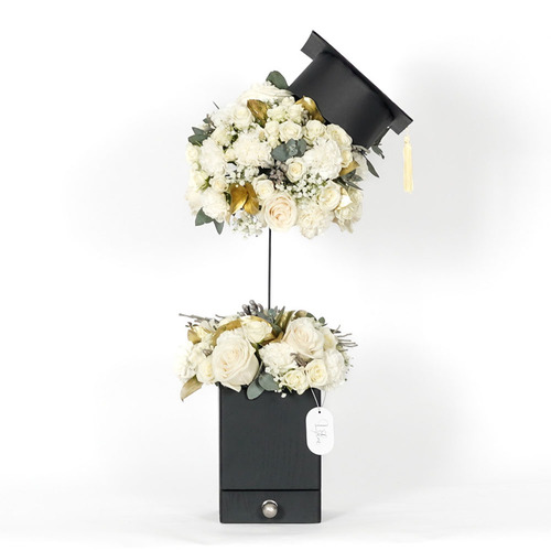 Meme - black wooden stand  contains mini graduation cap, white rose, white baby rose, white carnation and Belgian chocolate  Height 74 Width 36