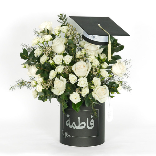 Fatma - Personalized black box contains mini graduation cap, white rose, white baby rose and wax flower . You can add chocolate box with this arrengment  Height 57 Width 54