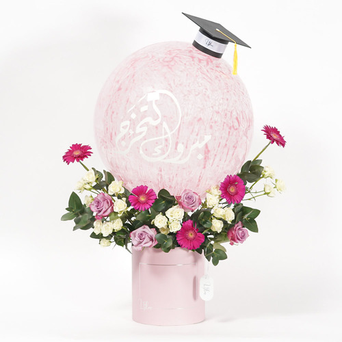 Joy - Pink box contains large size balloon ,mini graduation cap, gerbera, purple rose and white baby rose. You can add Belgian chocolate box with the bouquet  Height 76 Width 68