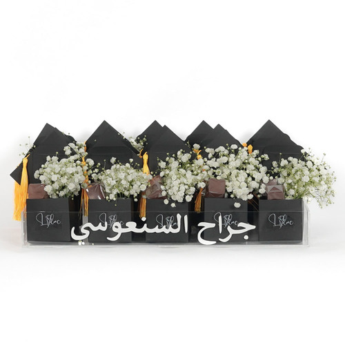 White flower cap - Personalized acrylic tray with 15 mini graduation cap boxes each box contains belgian chocolates and white gypsophila.   Hight 17   width 40  Optional writing on the item 18 characters.