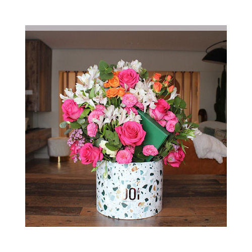 Costles - Terrazzo box contains fuchsia roses, fuchsia and orange baby roses, white alstroemeria flowers, green leaves with box of chocolates. Height: 50cm Width: 45cm