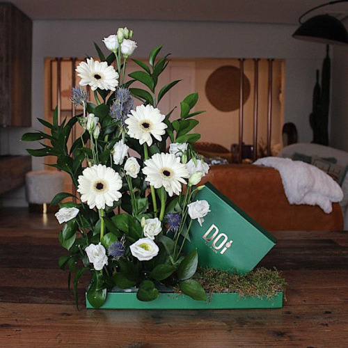 Greece - Tray contains white gerbera, eustoma, green leaves with box of chocolates. Height: 40cm Width: 35cm