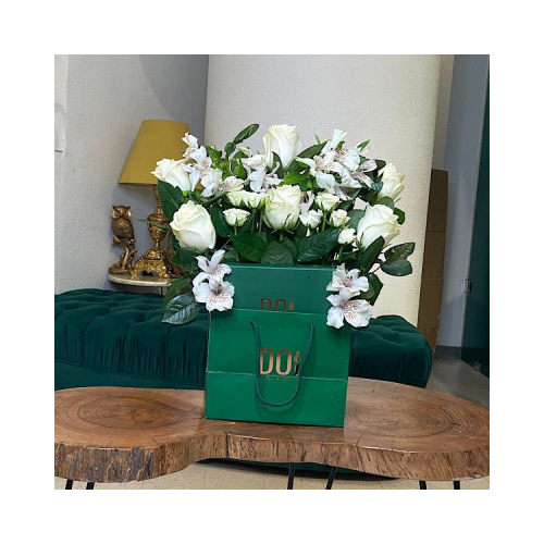 Amira - Green bag contains white roses, white baby roses, green leaves and box of chocolate. Height: 30cm Width: 20cm Sell by: Quantity