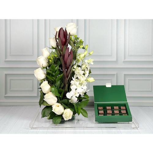 Haarlem - Tray contains white roses, green hypericum, white baby orchid and green leaves with box of chocolate. Height: 50cm Width: 40cm Sell by: Quantity