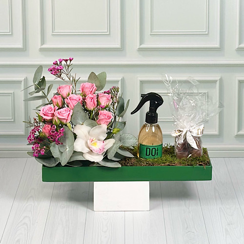 Tods - Green tray contains cymbidium, pink baby roses, green leaves with spray 150ml and chocolate.  Height: 45cm  Width: 35cm