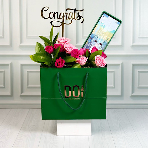 Graduate - Green bag contains pink and fuchsia baby roses and green leaves with money box and acrylic. Height: 40cm  Width: 30cm