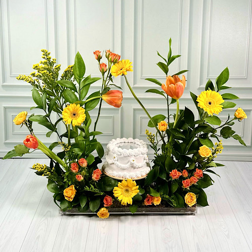 Yellow - Acrylic tray contains Yellow Gerbera, Orange Tulip, Yellow and Orange baby roses, Yellow Solidago and green leaves with mirror cake.Height: 50cmWidth: 40cm