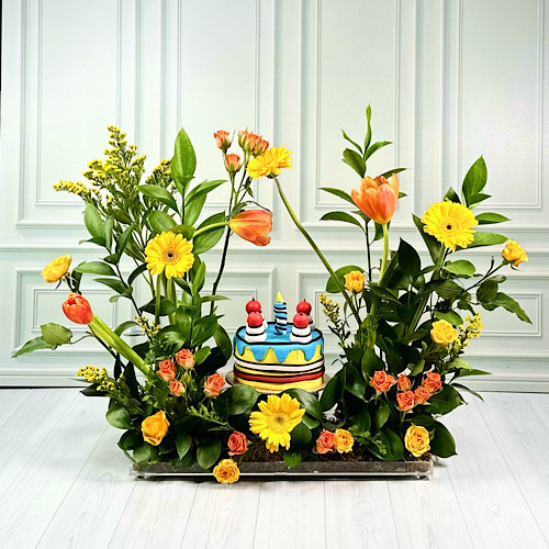 Candle - Acrylic tray contains Yellow Gerbera, Orange Tulip, Yellow and Orange baby roses, Yellow Solidago and green leaves with candle cake.Height: 50cmWidth: 40cm