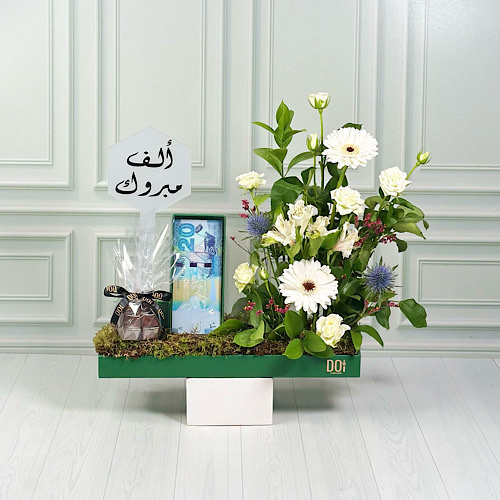 Flora - Green tray contains white grabera, white baby roses, white alstromeria, pink lemon grass and green leaves with chocolate, congrats acrylic and money box. Height: 40cm Width: 35cm