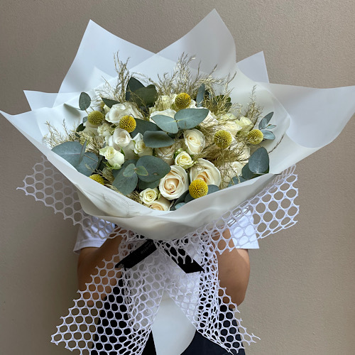 White blush - An arrangement of flowers wrapped in white mesh wrapping paper *Flower kind and color may slightly
differ based on availability.