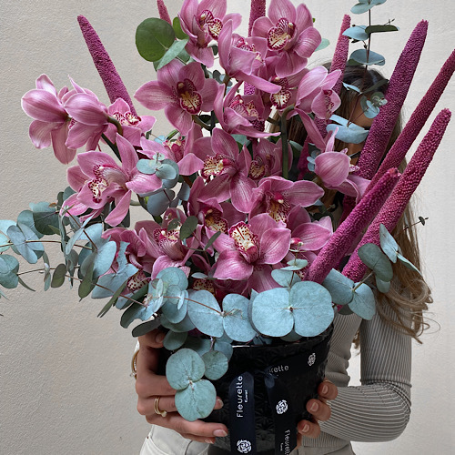 Exotic Cymbediums - Pink cymbediums arranged in a black ceramic vase*Flower kind and color may slightly
differ based on availability.