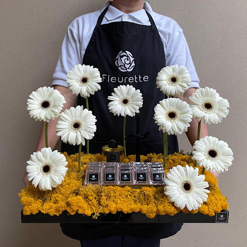 Bed of Gerberas II - Gerberas arranged in a black tray with 140ml rose code diffuser from 24 Fragrance and chocolates*Flower kind and color may slightly
differ based on availability.