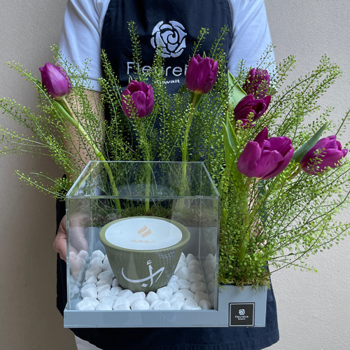 I purple you too - A grey acrylic box with small Shamaa candle 12cm arranged with flowers *Write the desired name on the candle in the message box L 22cm * H 30cm*Flower kind and color may slightly 
differ based on availability.