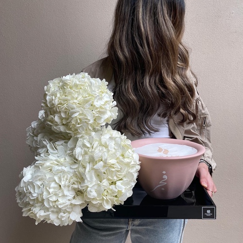 Cloud on cloud - An arrangement of hydrangeas with Shamaa candle in a black tray. (21cm candle shown in picture) *Please write the desired name on the candle in the message box. *L 50cm*Flower kind and color may slightly
differ based on availability.